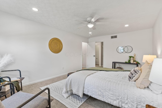 carpeted bedroom with ceiling fan and a textured ceiling