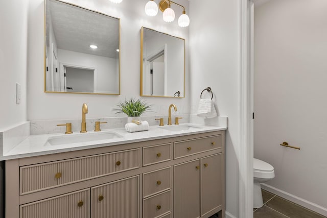 bathroom featuring tile patterned flooring, vanity, and toilet