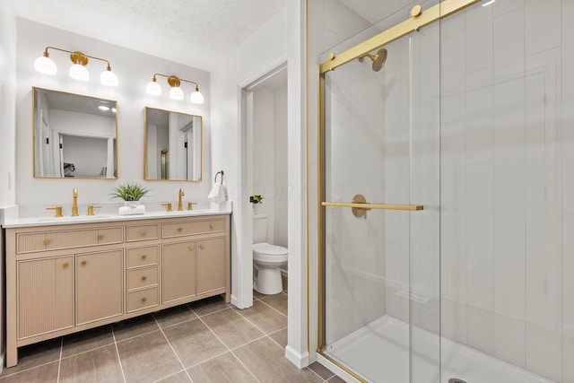 bathroom with tile patterned flooring, vanity, walk in shower, toilet, and a textured ceiling