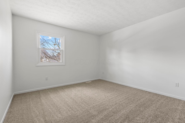 carpeted spare room with a textured ceiling