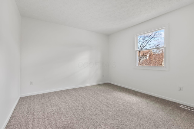 carpeted spare room featuring a textured ceiling