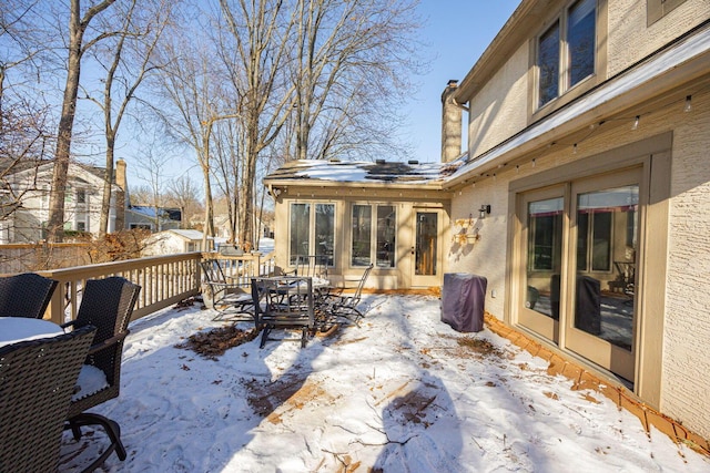 snow covered patio featuring a wooden deck