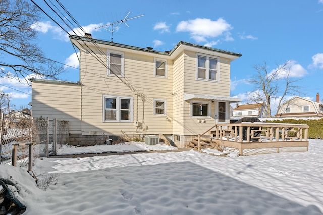 snow covered house featuring a wooden deck and central AC