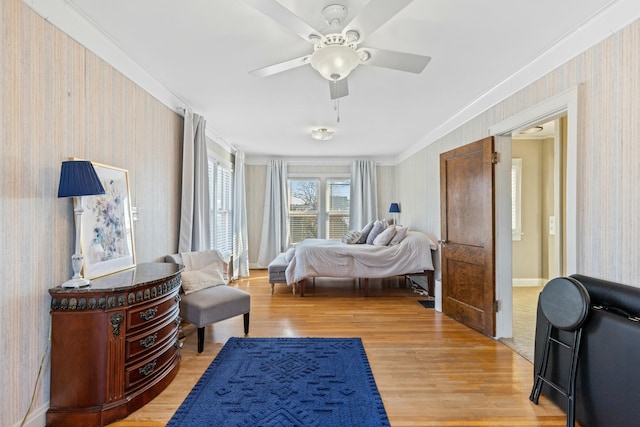 bedroom with ceiling fan, ornamental molding, and hardwood / wood-style floors