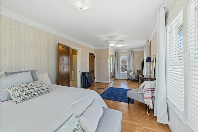 bedroom with ceiling fan, crown molding, and light hardwood / wood-style floors