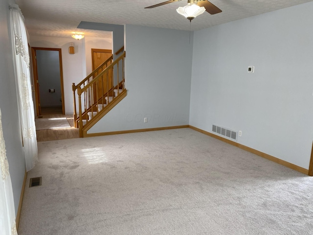 empty room featuring carpet floors, a textured ceiling, and ceiling fan