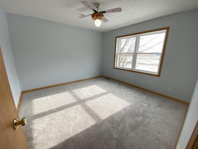 carpeted spare room with a textured ceiling and ceiling fan