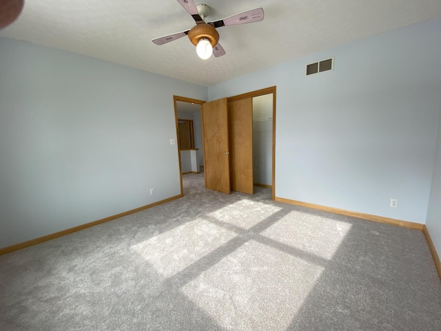 unfurnished bedroom featuring light carpet, a closet, and ceiling fan