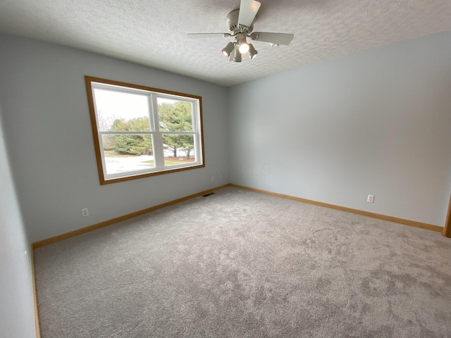 spare room featuring ceiling fan, a textured ceiling, and carpet floors