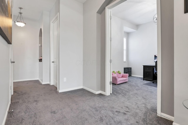 hallway featuring dark colored carpet