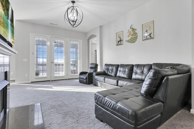 living room with carpet, a healthy amount of sunlight, and an inviting chandelier