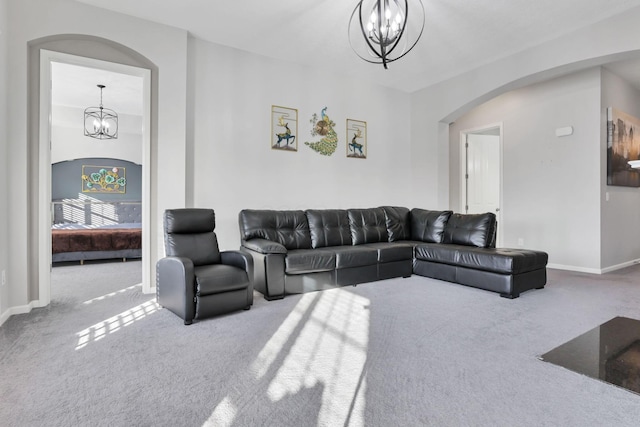 carpeted living room featuring a notable chandelier