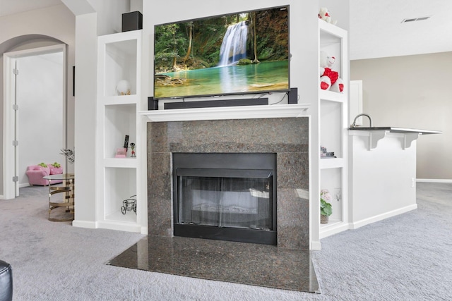 room details featuring a fireplace, built in features, and carpet floors