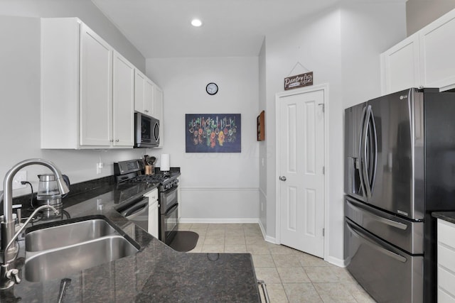 kitchen featuring sink, white cabinetry, dark stone countertops, and stainless steel appliances