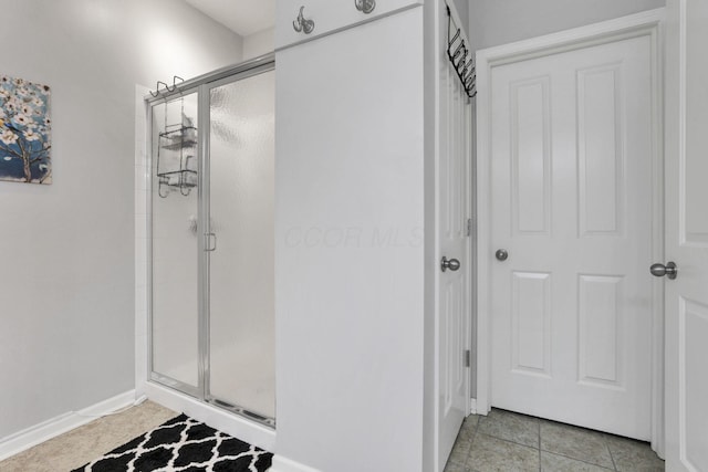 bathroom with tile patterned floors and a shower with door