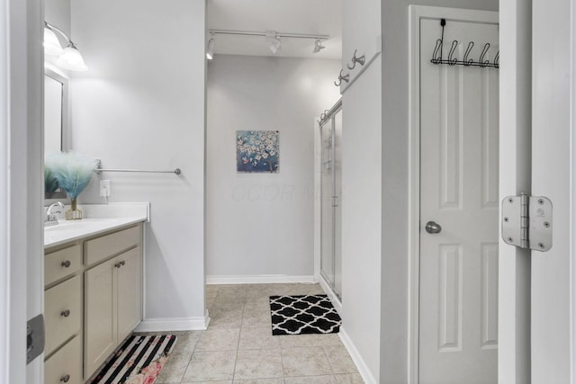 bathroom featuring a shower with shower door, tile patterned floors, and vanity