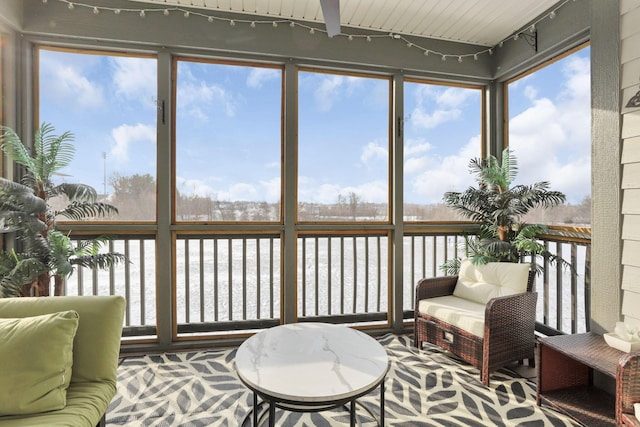 sunroom / solarium with a water view and a healthy amount of sunlight