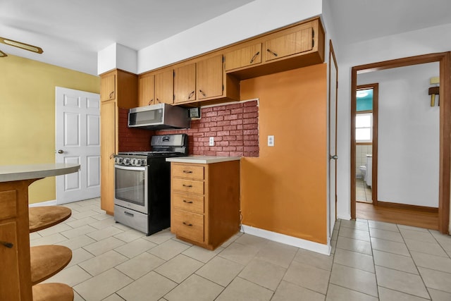 kitchen with light tile patterned floors and stainless steel appliances