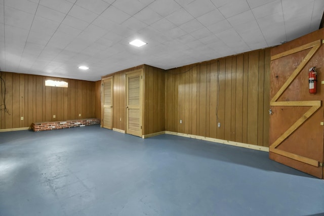 basement featuring wooden walls