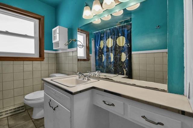 bathroom with tile walls, toilet, vanity, and tile patterned flooring