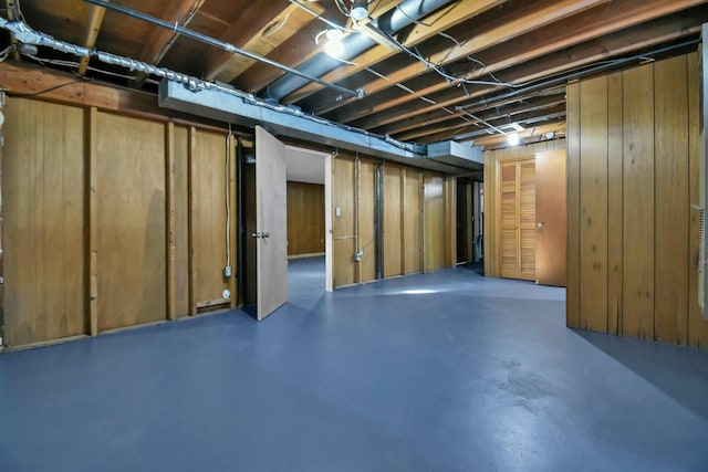 basement featuring wood walls