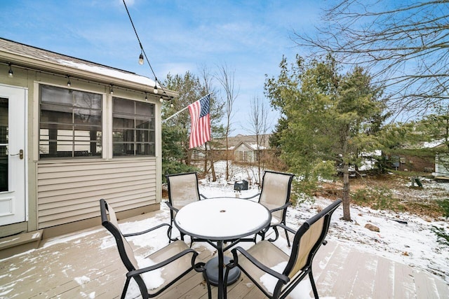 snow covered patio featuring a sunroom