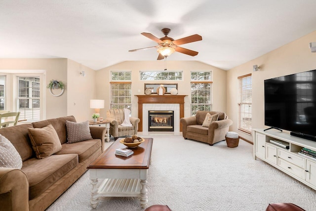 living room featuring a wealth of natural light, lofted ceiling, light colored carpet, and a fireplace