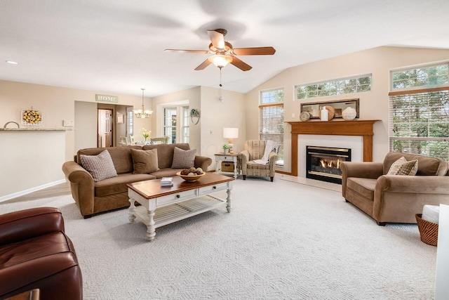 living room featuring lofted ceiling, ceiling fan with notable chandelier, and light carpet