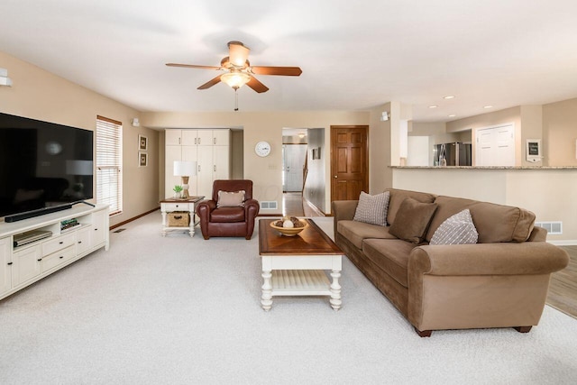 living room featuring ceiling fan and light colored carpet