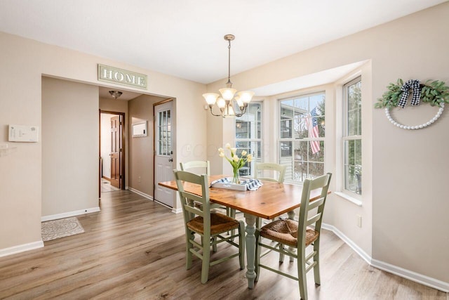 dining area with an inviting chandelier and hardwood / wood-style flooring