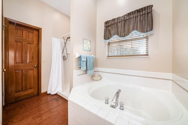 bathroom with hardwood / wood-style floors and shower with separate bathtub