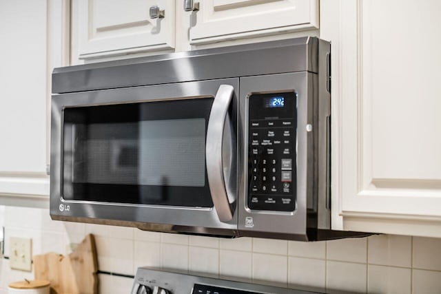 room details with tasteful backsplash and white cabinetry