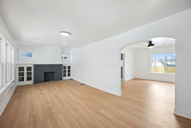 unfurnished living room featuring ceiling fan, light hardwood / wood-style flooring, and a fireplace