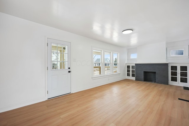 unfurnished living room with a fireplace and light wood-type flooring