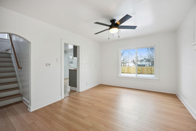 empty room with ceiling fan and light hardwood / wood-style floors