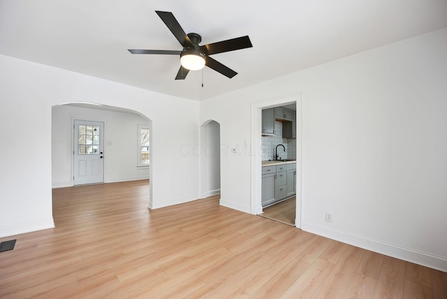 spare room with sink, ceiling fan, and light hardwood / wood-style floors