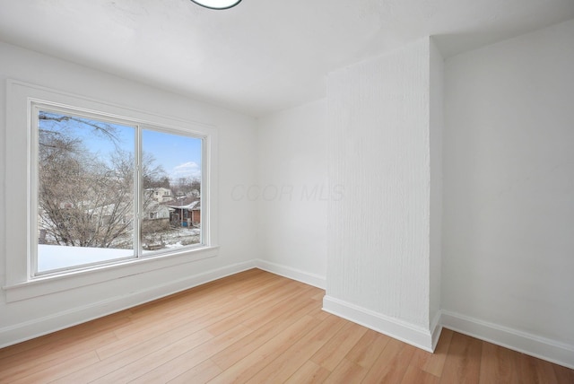 spare room with a healthy amount of sunlight and light hardwood / wood-style flooring