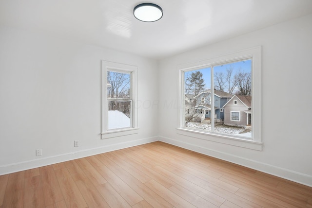 spare room with light hardwood / wood-style flooring and a wealth of natural light