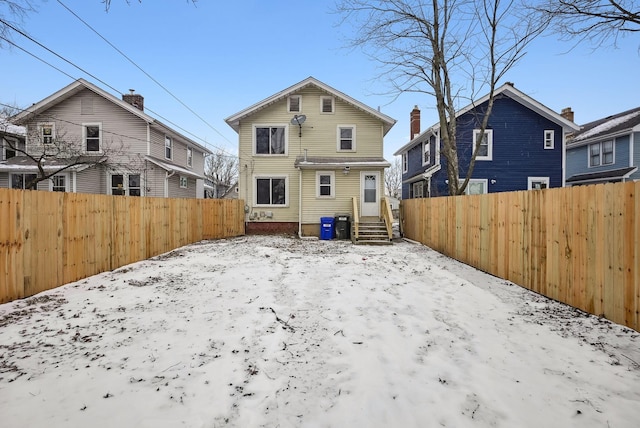 view of snow covered rear of property