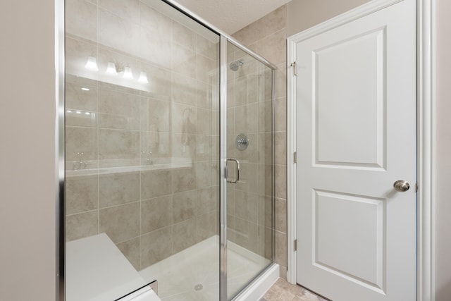 bathroom with tile patterned flooring and an enclosed shower