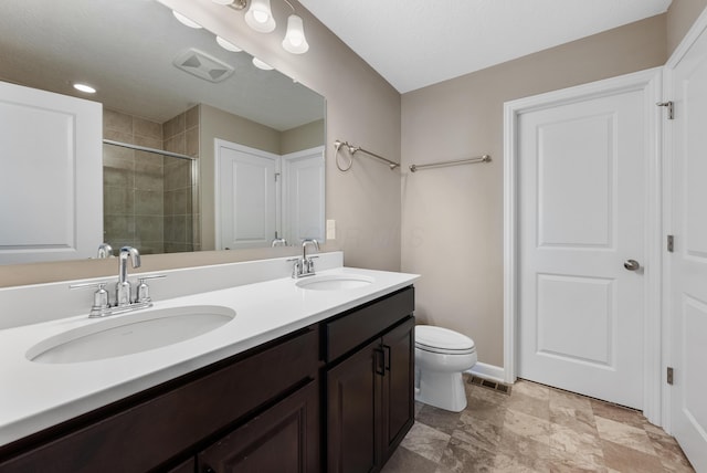 bathroom featuring toilet, an enclosed shower, and vanity