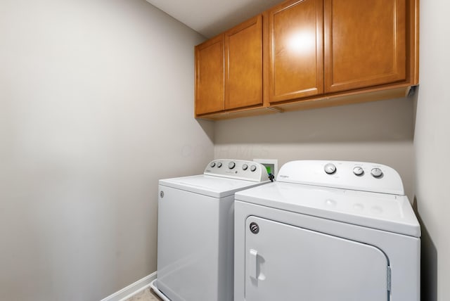 washroom featuring separate washer and dryer and cabinets