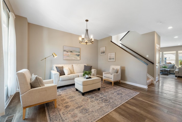 living room featuring a chandelier and dark wood-type flooring