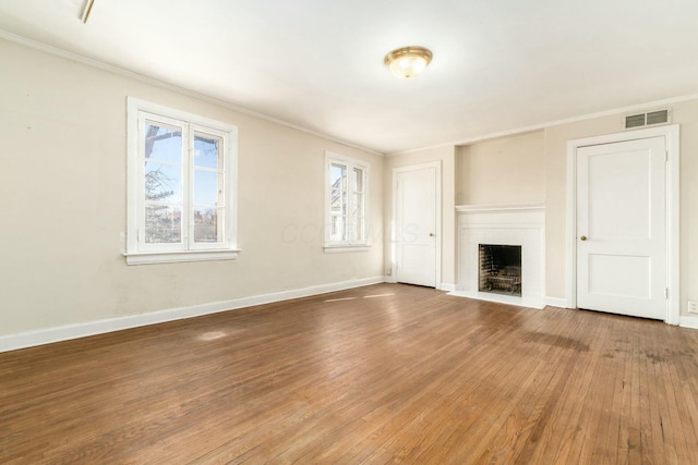 unfurnished living room with wood-type flooring and ornamental molding