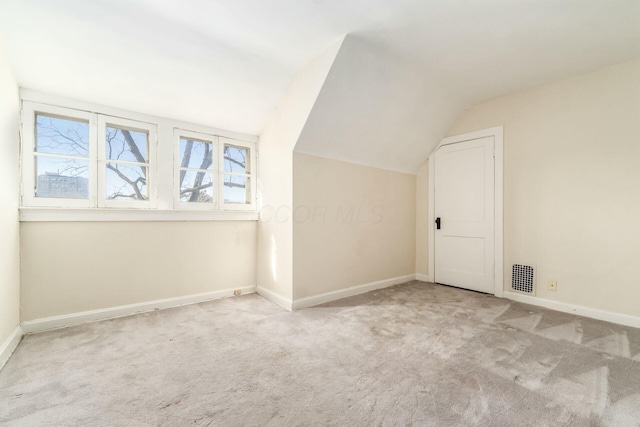 additional living space with vaulted ceiling and light carpet