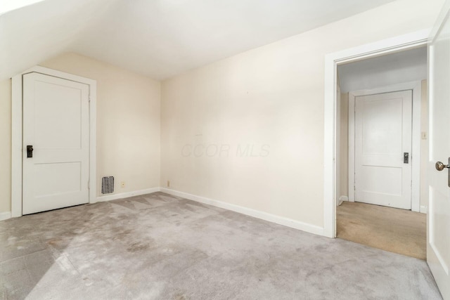 carpeted empty room featuring lofted ceiling