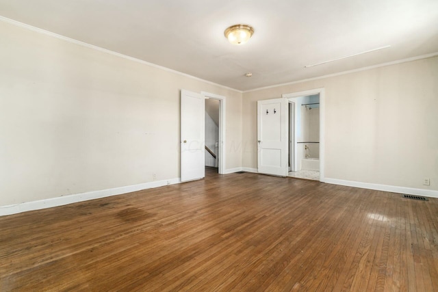 empty room featuring crown molding and dark wood-type flooring