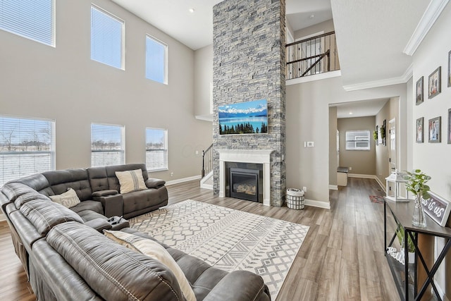 living room with a fireplace, hardwood / wood-style floors, plenty of natural light, and a high ceiling