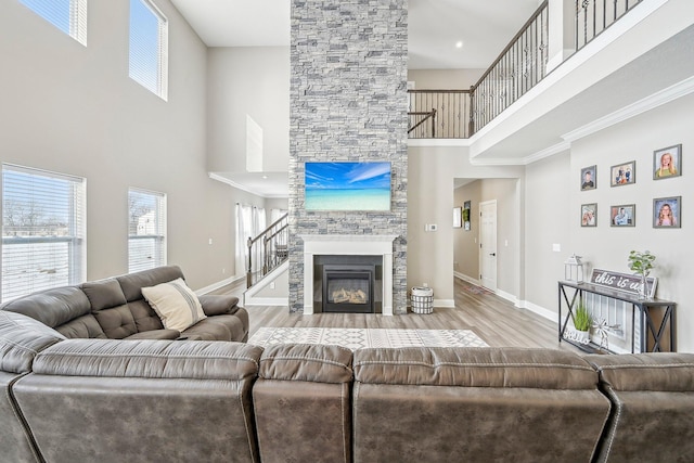 living room featuring a high ceiling, ornamental molding, and light hardwood / wood-style floors