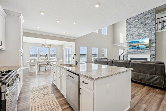 kitchen featuring sink, white cabinetry, light stone countertops, a kitchen island with sink, and stainless steel appliances